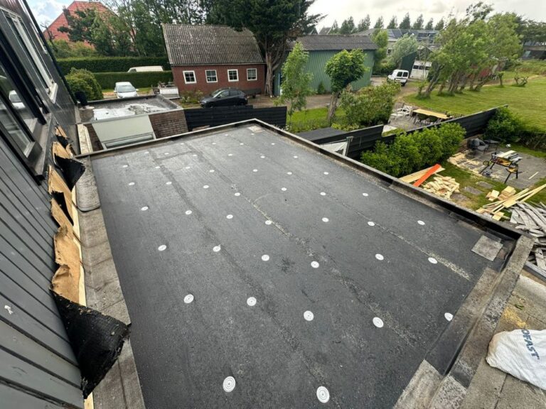 Plat dakconstructie met nieuwe waterdichting in stadstuin.