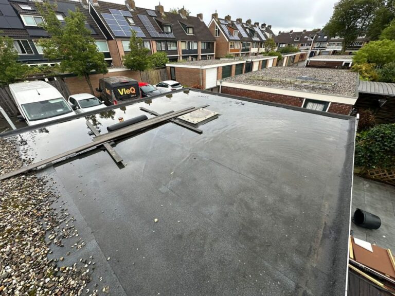 Plat dak met water en grind in wijk.
