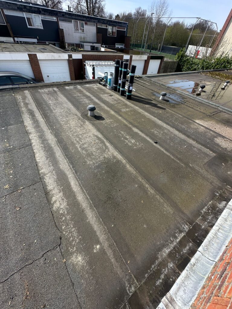 Plat dak met loodsen op de achtergrond.