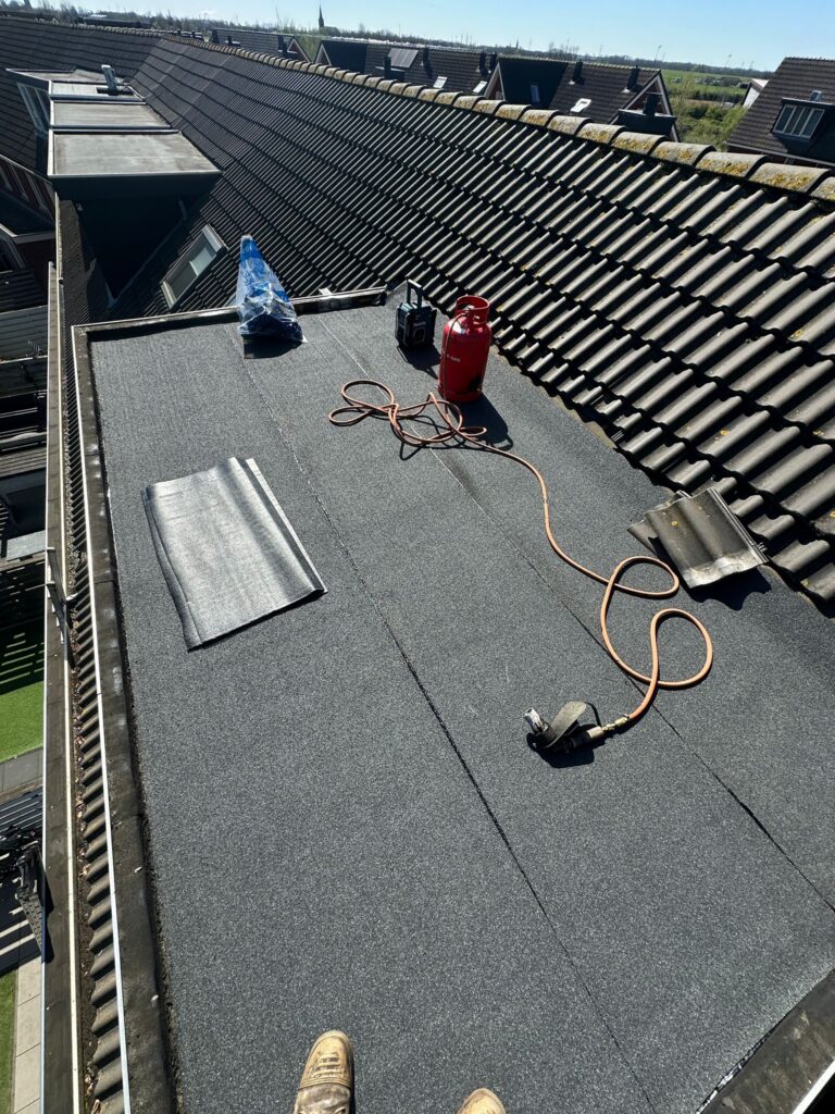 Plat dak met gereedschap en gasfles.