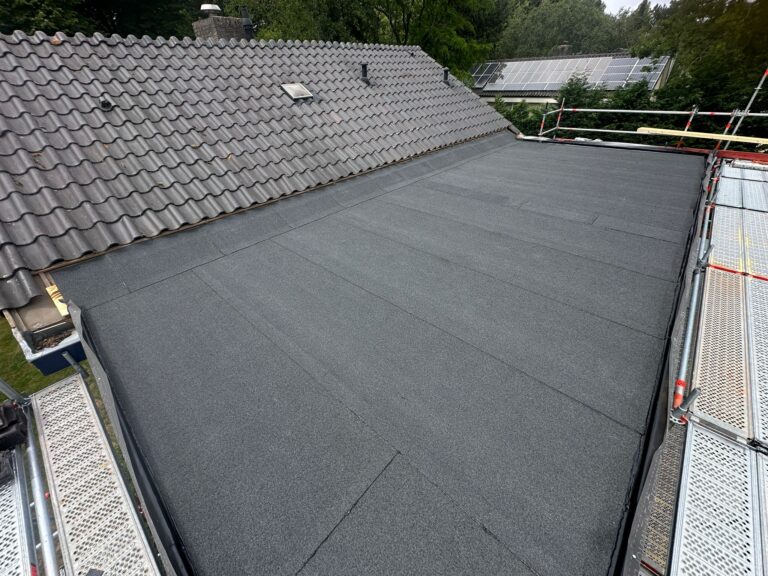 Nieuw plat dak naast pannendak en zonnepanelen.