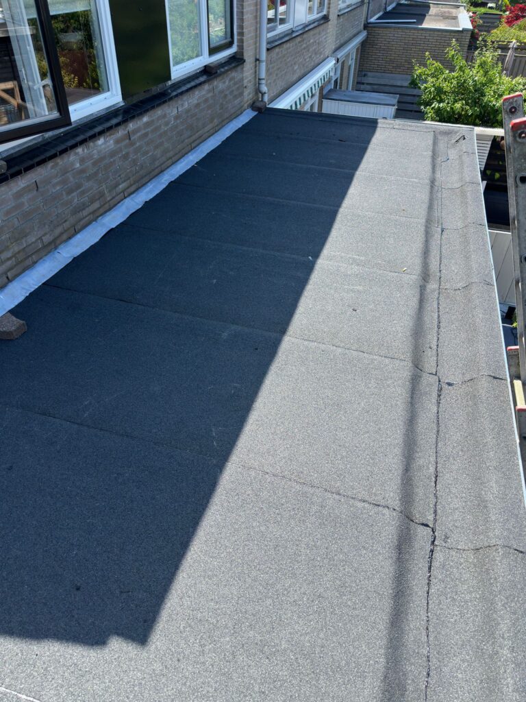 Plat dak met zwart bitumen bedekking